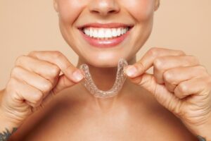 woman holding clear aligners